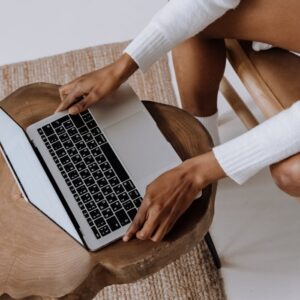 Close-up of a woman typing on a laptop indoors, focusing on technology and modern lifestyle.